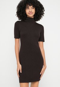 Šaty s krátkym rukávom, priliehavé, z tmavohnedého žíhaného úpletu. Majú vysoký výstrih a jednoduchú, elegantnú siluetu.