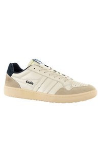 Sneaker bianco in pelle con dettagli in suede beige e tab sul tallone blu. Presenta un design a tre strisce e una punta perforata per la traspirabilità.