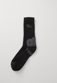 Svarte knelange sokker med ribbet tekstur, som har grått logo og sirkulært grafisk design på siden.