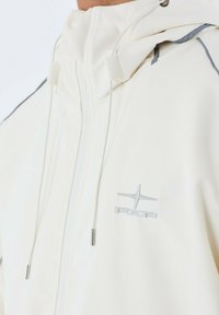 Chaqueta blanca con capucha y detalles plateados, con una textura suave, cierre de cremallera y logotipo bordado en el pecho. Presenta cordones ajustables.