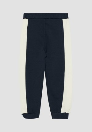 Pantalon de sport bleu marine avec panneaux latéraux blancs, taille élastique et chevilles resserrées, posé à plat sur un fond gris clair.