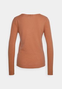 Pull tricoté à manches longues, près du corps, de couleur marron clair, avec un petit détail de bouton métallique en haut du dos, montré de dos sur fond blanc.