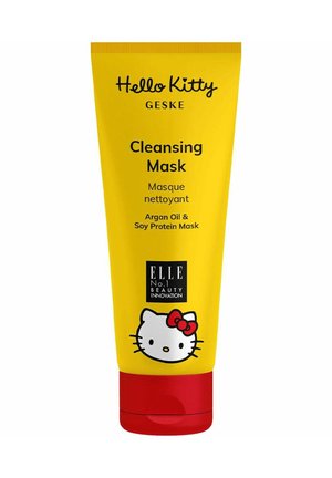 Tube jaune à presser étiqueté "Masque Nettoyant" avec du texte noir, présentant un chat en dessin animé avec un nœud. Capuchon inférieur rouge. Contient de l'huile d'argan et des protéines de soja.