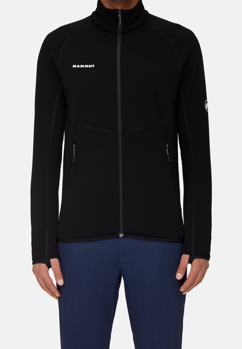 Giacca in pile nera con colletto alto, zip completa e tasche con zip. Presenta cuciture a contrasto e un logo sul petto.