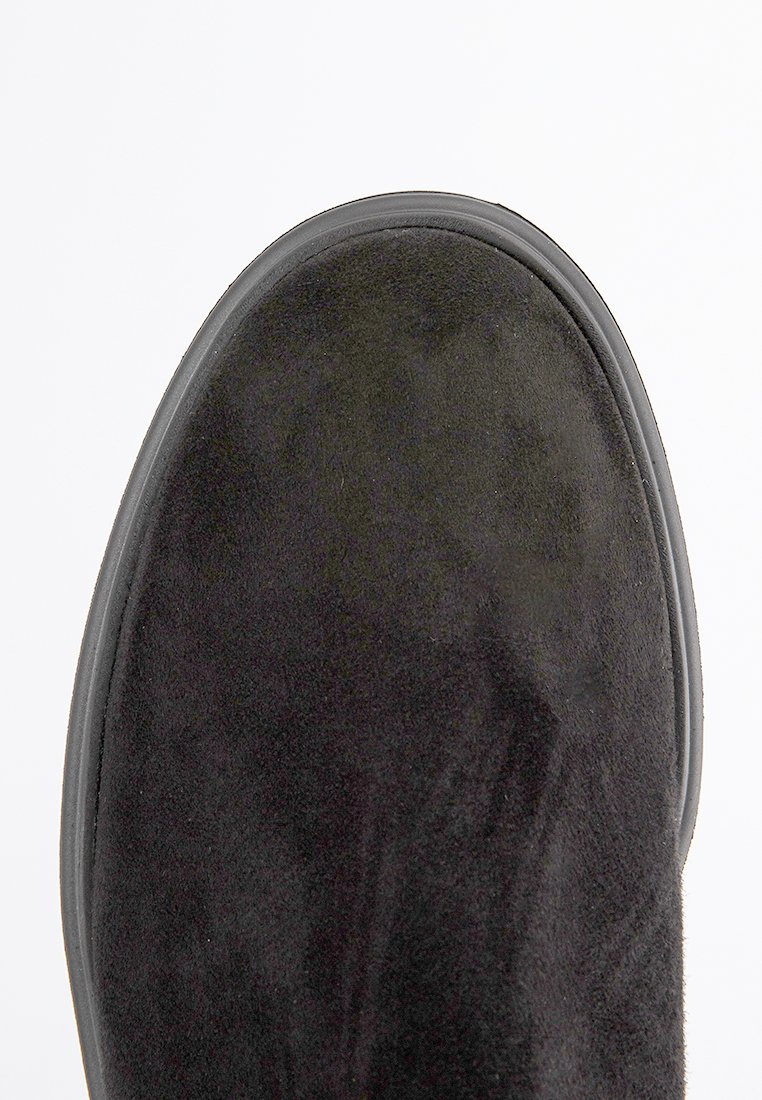 Stivale alla caviglia in suede nero con punta arrotondata e suola in gomma, caratterizzato da una texture liscia e un design minimalista senza hardware o dettagli.