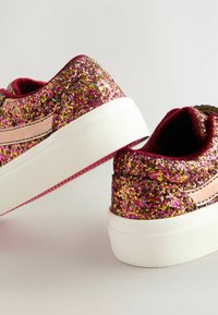 Sneakers ricoperti di glitter in rosa e oro con suola in gomma bianca e dettagli rosa. Presentano una morbida fodera interna. Design con punta arrotondata.
