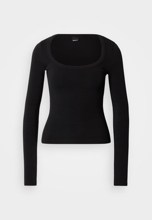 Haut noir à manches longues avec un col rond, coupe ajustée et texture côtelée, fabriqué en matière douce et extensible. Aucun motif ou accent visible.