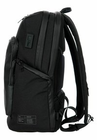 Mochila negra hecha de tela reciclada, con un diseño elegante, múltiples cremalleras, correas acolchadas y un bolsillo lateral texturizado.