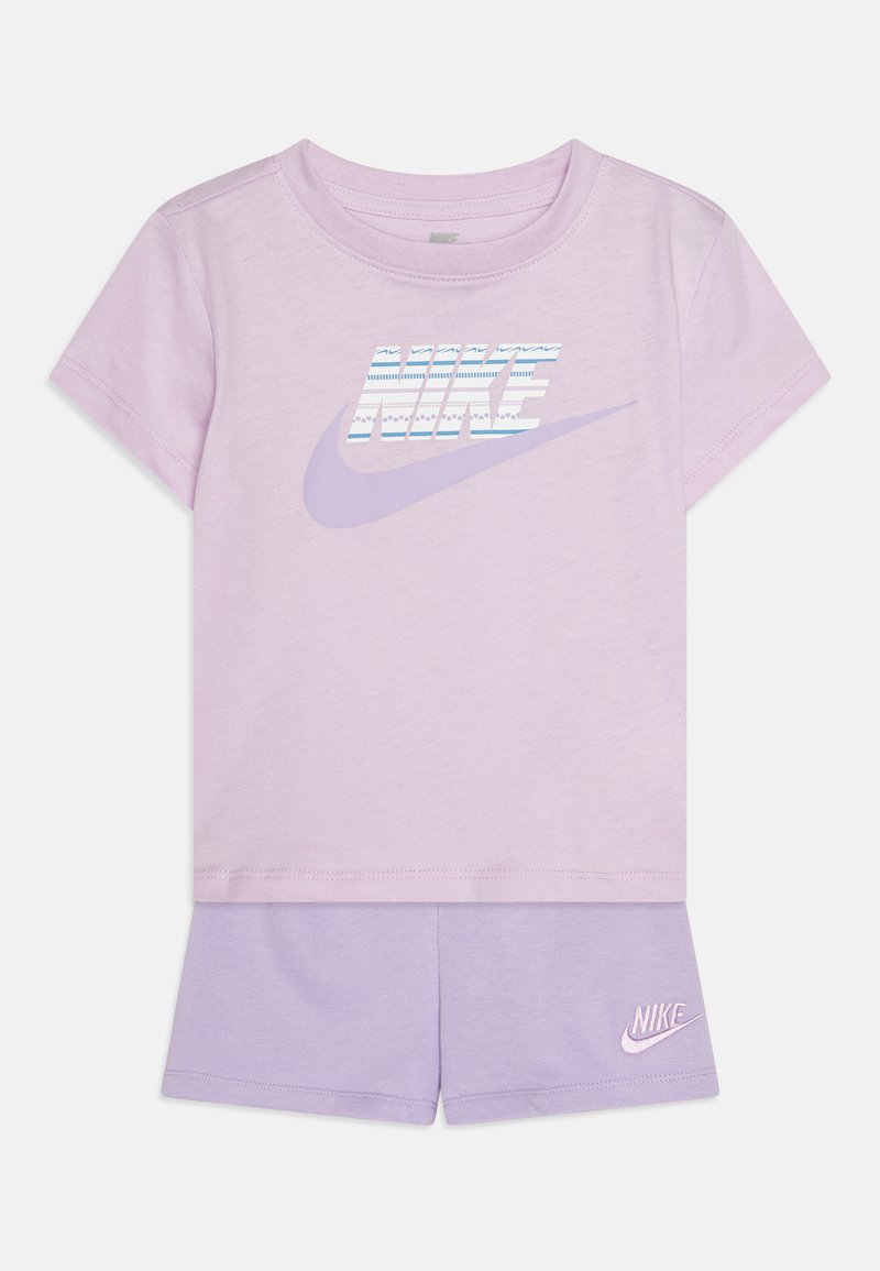 Μωβ βαμβακερή μπλούζα t-shirt με κοντά μανίκια και λογότυπο Nike σε μπλε και άσπρες ρίγες. Συνοδεύεται από μωβ σορτσάκι με μικρό λογότυπο.