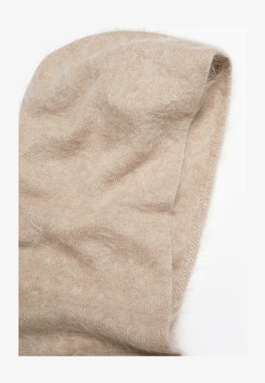 Beige knitted shawl made from soft, fluffy material. Features a light texture and slightly woven pattern with uneven edges.