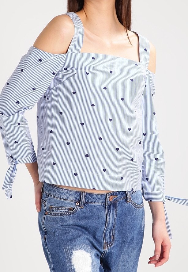 Top a spalle scoperte a righe blu e bianche con motivi a cuore; presenta maniche lunghe con dettagli a cravatta e un orlo dritto cropped.