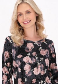 Blomsterprint top med en sort baggrund, rund udskæring og blød tekstur, med pink og blå rosemønstre overalt.