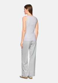 Gray sleeveless top with a round neckline paired with light gray wide-leg trousers. The fabric appears soft and smooth.
