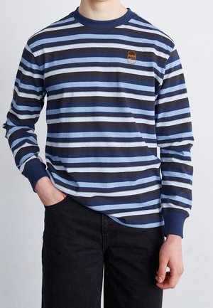 Langarmshirt mit blauen und schwarzen horizontalen Streifen, versehen mit einem kleinen orangefarbenen Logo. Hergestellt aus weichem Material, mit gerippten Bündchen und Ausschnitt.