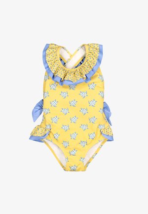 Bañador amarillo para niño pequeño con patrón de tortugas azules, cuello azul con volantes, lazos laterales y aberturas de piernas con volantes.