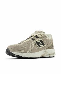 Beige sportieve schoen van mesh en synthetisch materiaal, met een gevoerde zool, donkere accenten en een geprofileerde buitenzool voor grip.