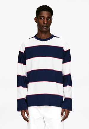 Bawełniana koszula z długim rękawem o horyzontalnych granatowo-białych paskach, ozdobiona cienkimi czerwonymi liniami, z okrągłym dekoltem i luźnym krojem.