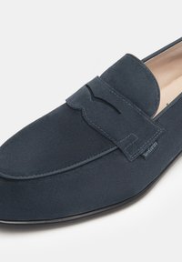 Dunkelblauvelours-Leder Slipper mit einem dekorativen umgeschlagenen Klappen und Stitching-Detail. Glatte Textur und runde Zehenpartie. Schwarze Gummisohle.