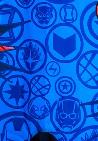 Blue fabric featuring various superhero icons and symbols in darker blue circles. Design includes shapes like shields, masks, and stars.