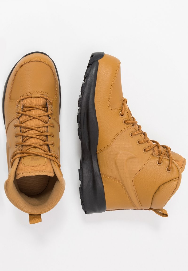 Bottines en cuir tan avec des semelles en caoutchouc noir, dotées d'un laçage, d'un col rembourré et d'une bande de traction à l'arrière.