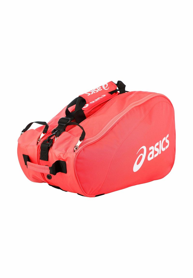 Sac de sport ASICS rouge vif avec des bretelles noires réglables et plusieurs compartiments zippés.