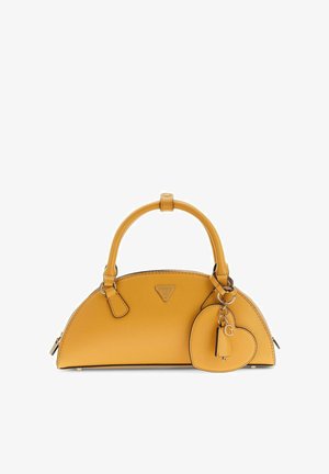 Sac à main jaune avec une poignée arrondie sur le dessus et un porte-clés en forme de cœur suspendu sur le côté, sur fond blanc.