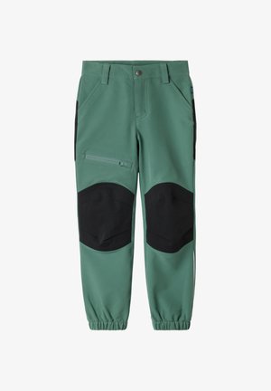 Groene werkbroek met zwarte kniestukken, zijritszak aan de linker dij, riemlussen en elastische boorden bij de enkels.