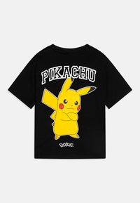 Juodas medvilninis marškinėlis su dideliu geltonu Pikachu grafiką ant nugaros, virš personažo esantis baltas tekstas "PIKACHU".