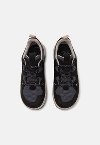 Sapatilhas atléticas pretas e cinzas com materiais em malha e camurça, colarinho acolchoado, design de atacadores e sola de borracha com aderência texturizada.