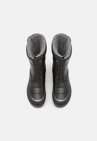 Schwarze isolierte Stiefel mit glänzender Oberfläche, ausgestattet mit einem Reißverschluss, Futter aus Kunstpelz und einer strukturierten Gummisohle. Runder Zehenbereich.