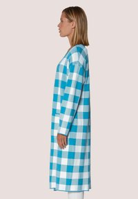 Turquoise en witte geblokte lange jas, gemaakt van geweven stof, met lange mouwen en een rechte pasvorm, gezien vanaf de zijkant.
