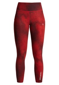 Czerwone legginsy z wzorem plam, wysoki stan i gładki materiał. Logo CALVIN KLEIN nadrukowane na dolnej części nogawki w kolorze białym.