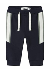Marineblauwe joggingbroek met witte en groene zijstrepen, elastische tailleband en een trekkoord. Gemaakt van een zachte, textuurstof.