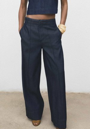 Donkerdenim wijde broek met hoge taille, voorzakken, zichtbare naden en een gladde textuur, gecombineerd met een bijpassende cropped top.