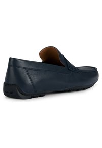 Scarpa in pelle blu navy slip-on con design mocassino, caratterizzata da una punta arrotondata e un interno marrone a contrasto. Marchio GEox sul tallone.