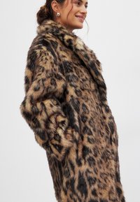 Leopardenmuster Fleece-Mantel mit weicher Textur, Kragen und seitlichen Taschen. Das Design weist Variationen in braunen und schwarzen Mustern auf.