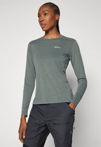 Long-sleeve, lightweight, moss-green shirt with a round neck and a small logo on the chest. Smooth texture, ideal for outdoor activities.