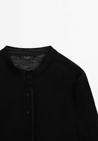 Cardigan noir léger en maille avec col rond et boutons noirs à l'avant, présenté à plat sur fond blanc.