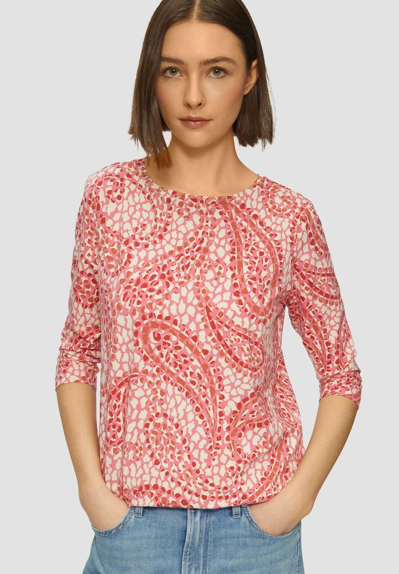 Lange mouwen roze top met een bloemenpatroon; lichte stof; ronde halslijn; losse pasvorm; heeft een abstract ontwerp in donkerdere tinten roze.