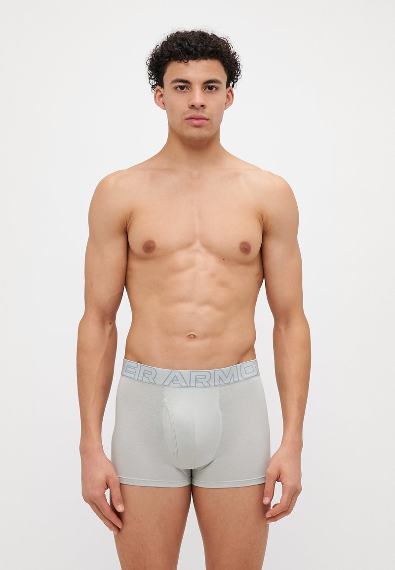 Šedé boxerky s modrým elastickým páskem, na kterém je tučně vytištěno "ARMOR". Hladká textura, přiléhavý střih a pokrytí do poloviny stehna.