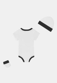 Body blanc à manches courtes avec un col côtelé noir, accompagné d'un chapeau et de chaussettes assortis à bord noir. Matière en coton doux.