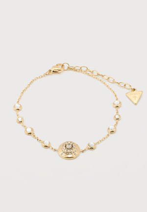 Fijn gouden kettingarmband met kleine heldere stenen en een centraal rond hangertje bezet met kristallen, voorzien van verstelbare sluiting en merklabel.