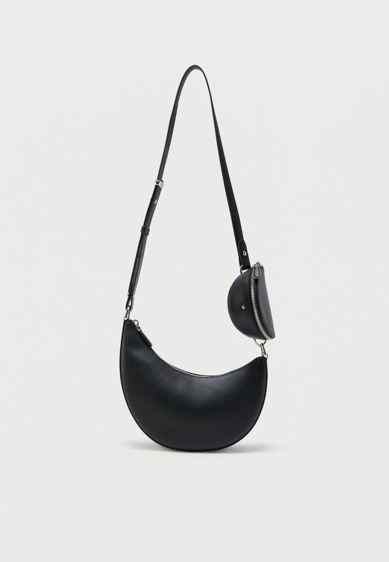 Μαύρο δερμάτινο τσάντα χιαστί σε σχήμα ημισελήνου με μακρύ ρυθμιζόμενο λουρί και μικρό στρογγυλό θήκη με φερμουάρ προσαρτημένη κοντά στο λουρί.