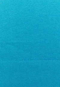 Helder turquoise gebreide stof met een fijne ribbelstructuur, met een dikkere ribbelsrand aan de onderkant.