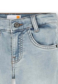 Jeans di denim blu chiaro con una finitura sbiadita, design a cinque tasche, cuciture a contrasto e un bottone in metallo con logo.