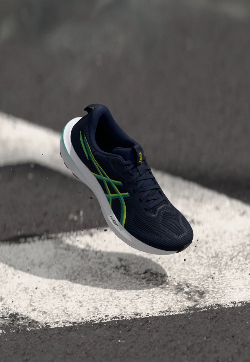 Navy running shoe featuring a mesh upper, green accents, textured surface, and a white midsole with the label "FF BOOST."