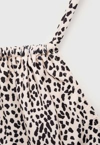 Top z leopardjim vzorom in črnimi pikami na svetlo bež ozadju. Ima nabran ovratnik in tanke nastavljive naramnice. Mehka tekstura tkanine.