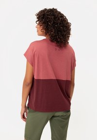 Camiseta de manga corta en color marrón y rosa con un corte relajado. Presenta un logo sencillo en la parte de atrás y una textura de algodón suave.