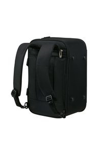 Sac à dos noir avec bretelles rembourrées, poches avant zippées, tissu texturé et coins arrondis. Comprend des pieds plats pour une meilleure stabilité.