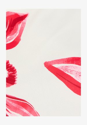 Empreintes de baisers au rouge à lèvres rouge et motif de chouchou rouge sur un fond de tissu blanc.